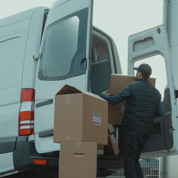 man in blue jacket and blue denim jeans sitting on brown cardboard box